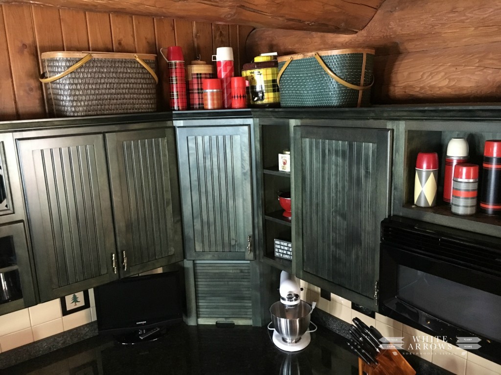green cabinets-thermos-log home-picnic basket