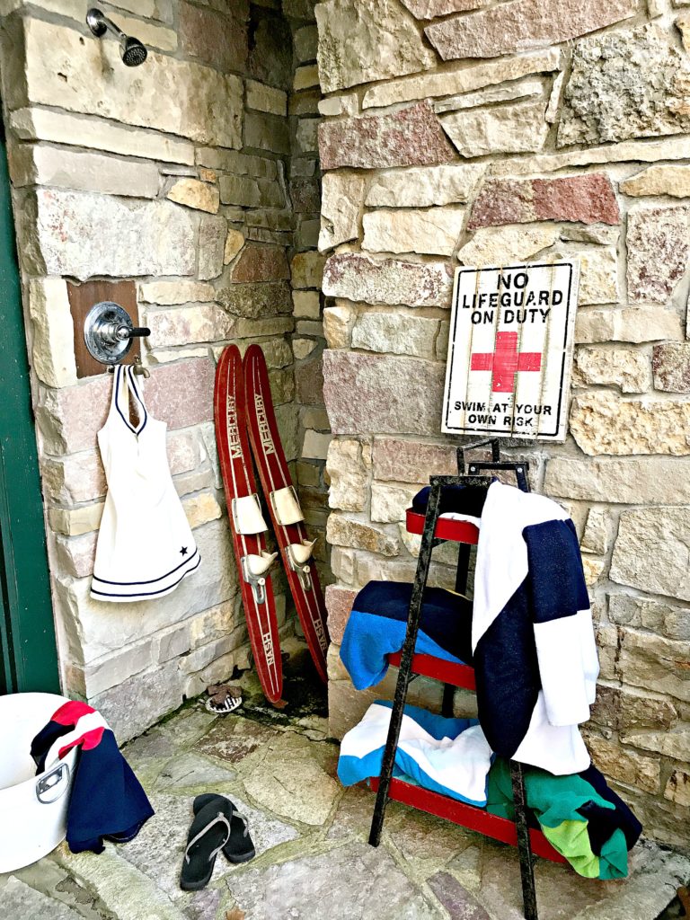 Our lake house outdoor shower with vintage swimming suits hanging.