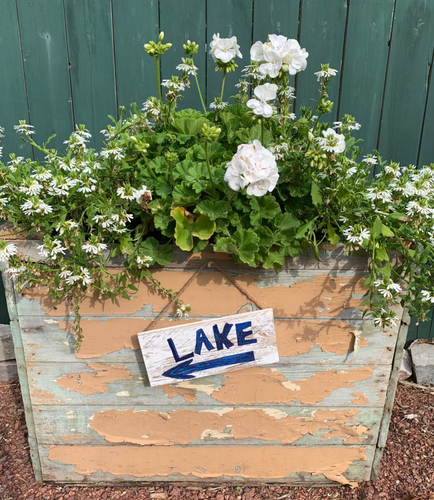 Chippy Wood box full of flowers with sign pointing to the Lake