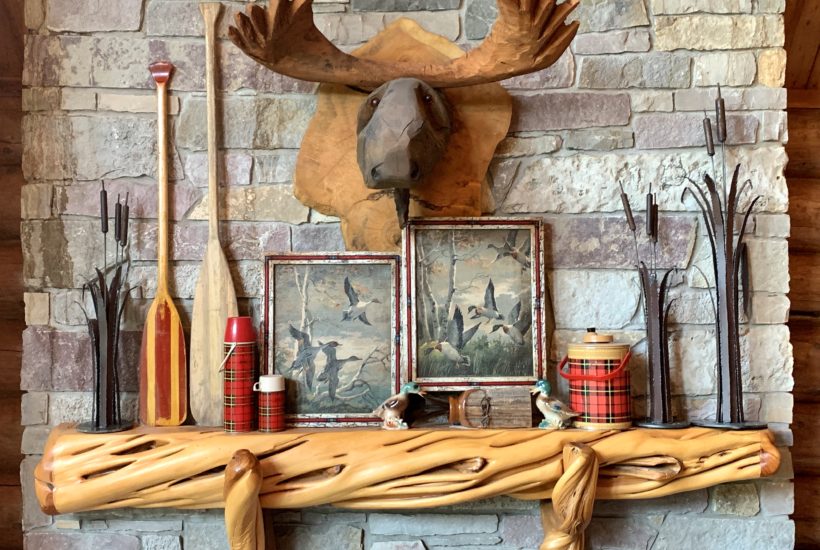 Carved wood mantel with plaid and duck hunting decor