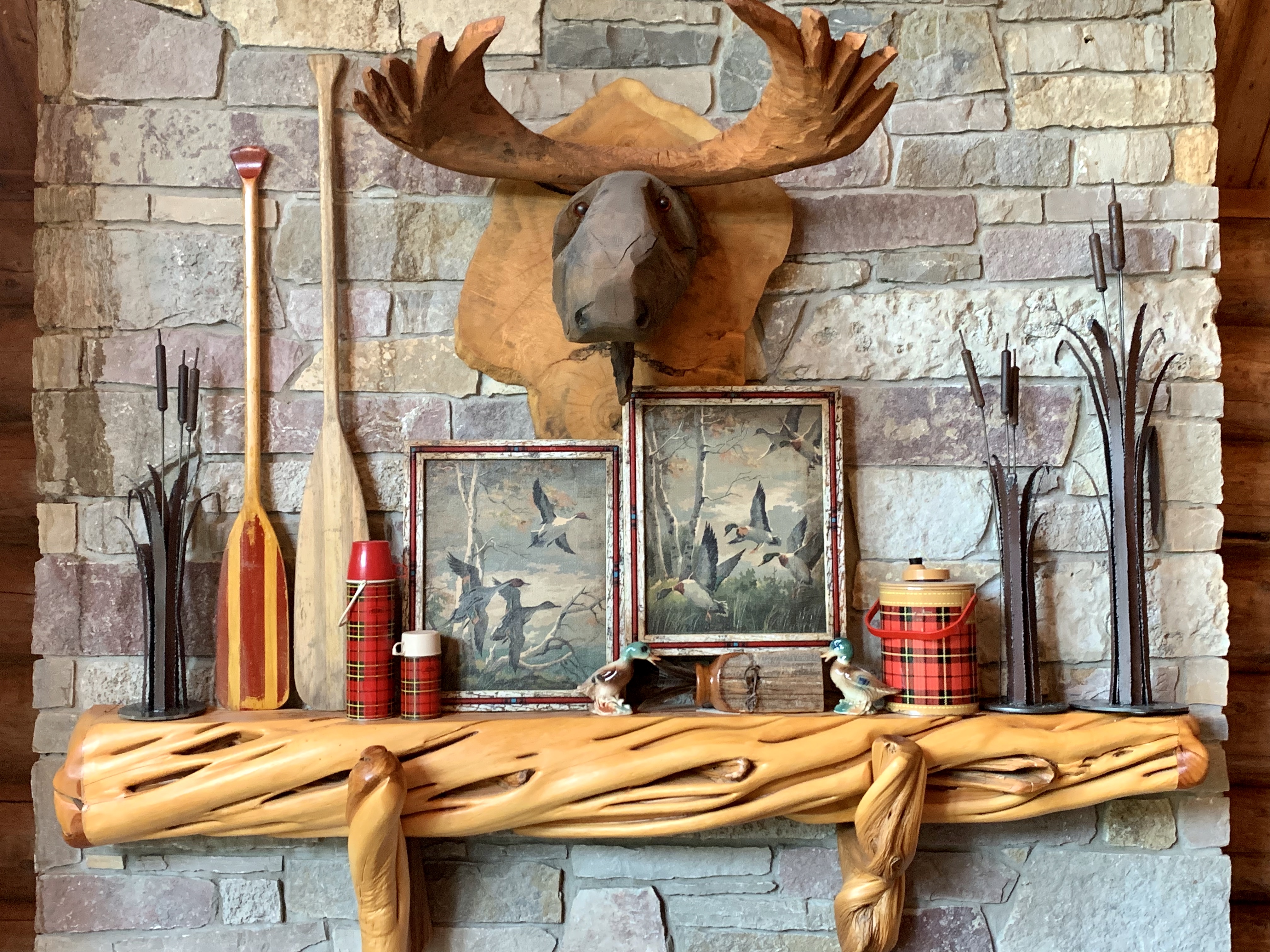 Carved wood mantel with plaid and duck hunting decor