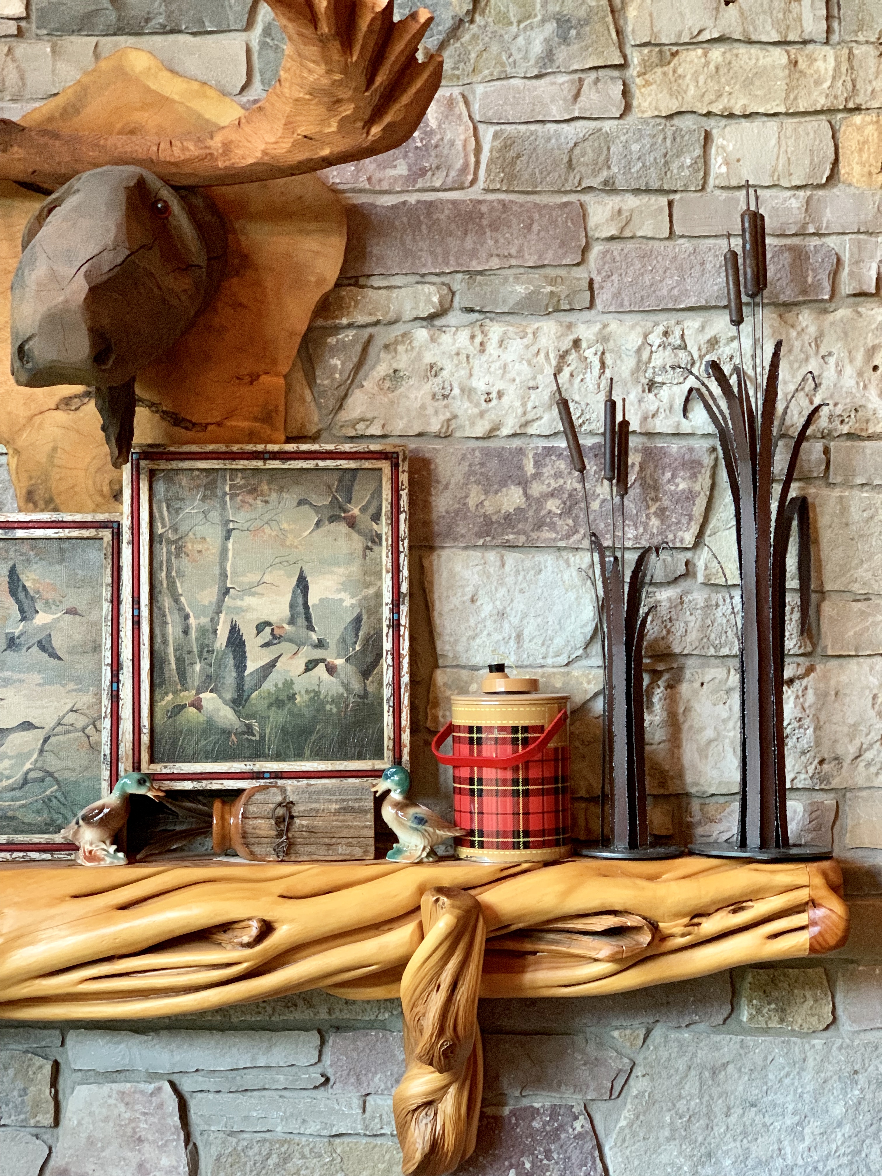 rustic wood mantel decorated with red plaid and carved moose head
