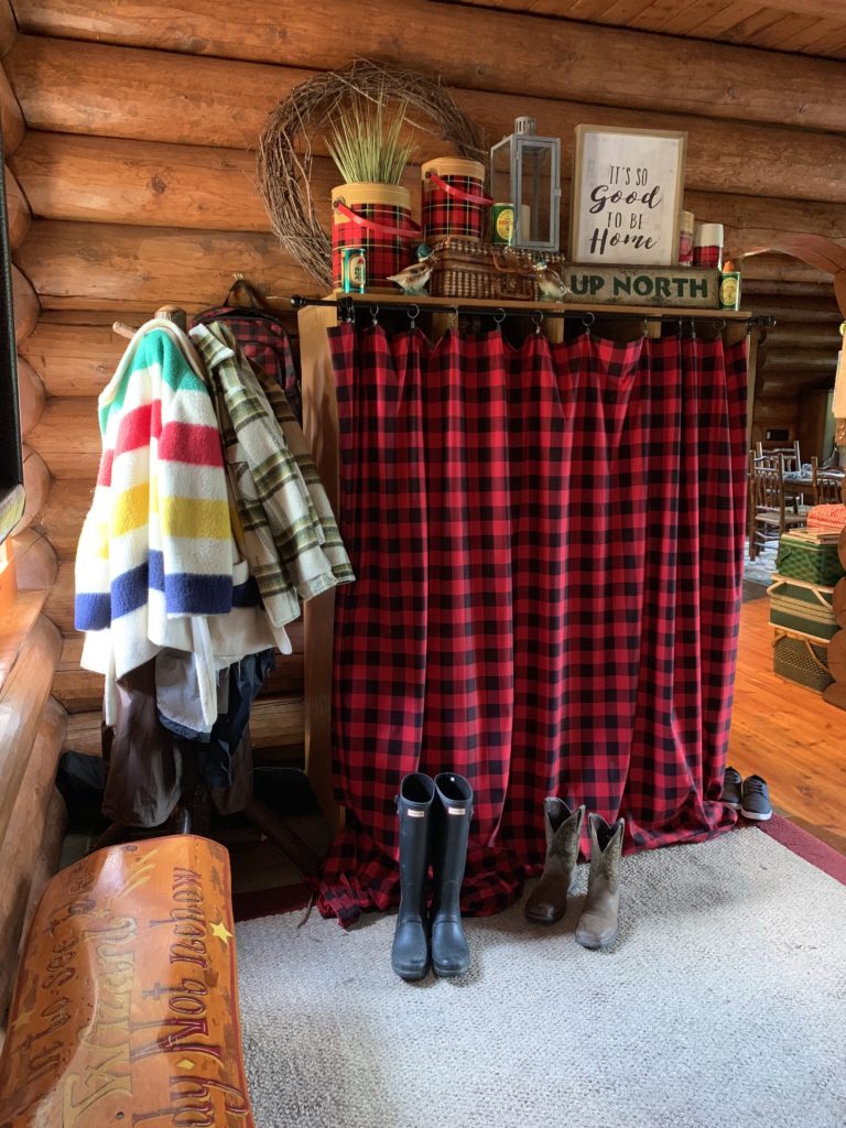 Fall Decor in entry way. Cubbies hidden behind buffalo plaid curtain.