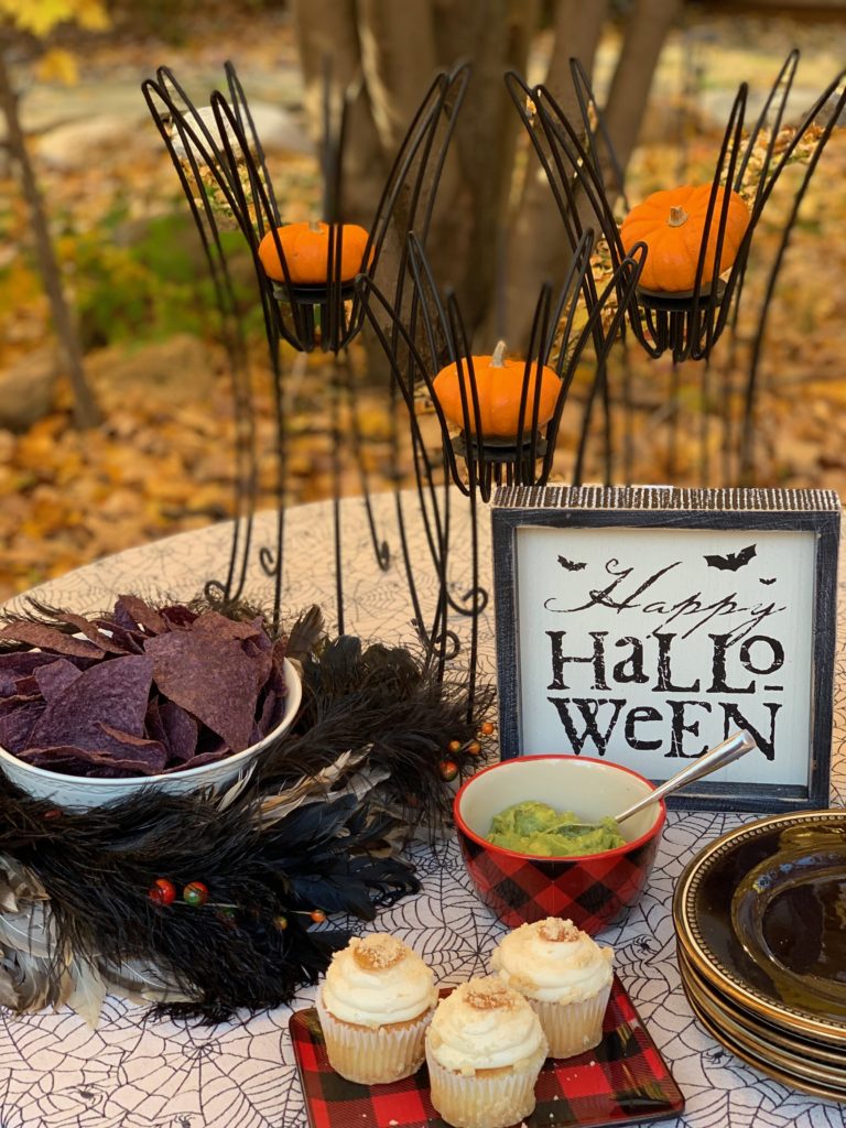 Halloween treats of chips and guacamole and apple cupcakes