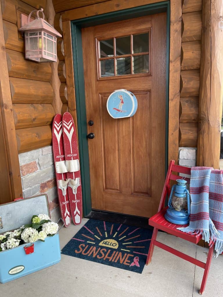 lake house porch decor with vintage cooler, chair and blanket