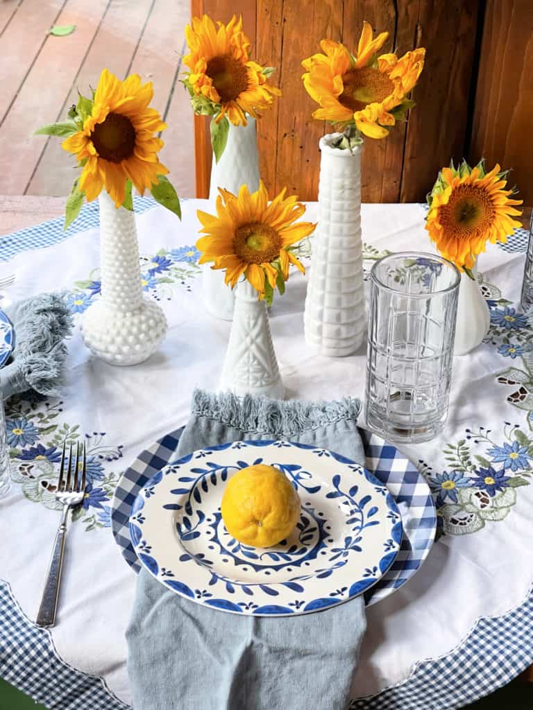 Sunroom Table set for Summer with blue and whites, vintage linens and lemons, milk glass and sunflowers