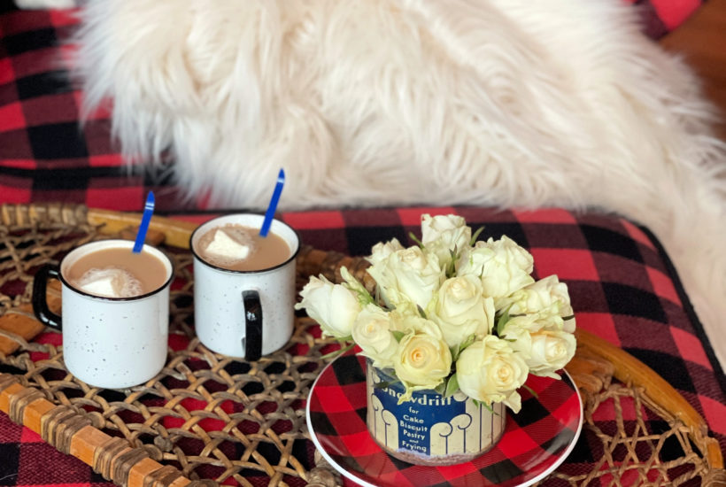 Winter decor of roses in Vintage Snowdrift Tin on buffalo plaid plate on snowshoe tray and hot cocoa