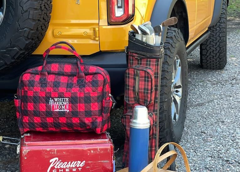 Ford Bronco with Vintage Finds, thermos cooler, plaids, picnic basket, golf bag and clubs, buffalo plaid